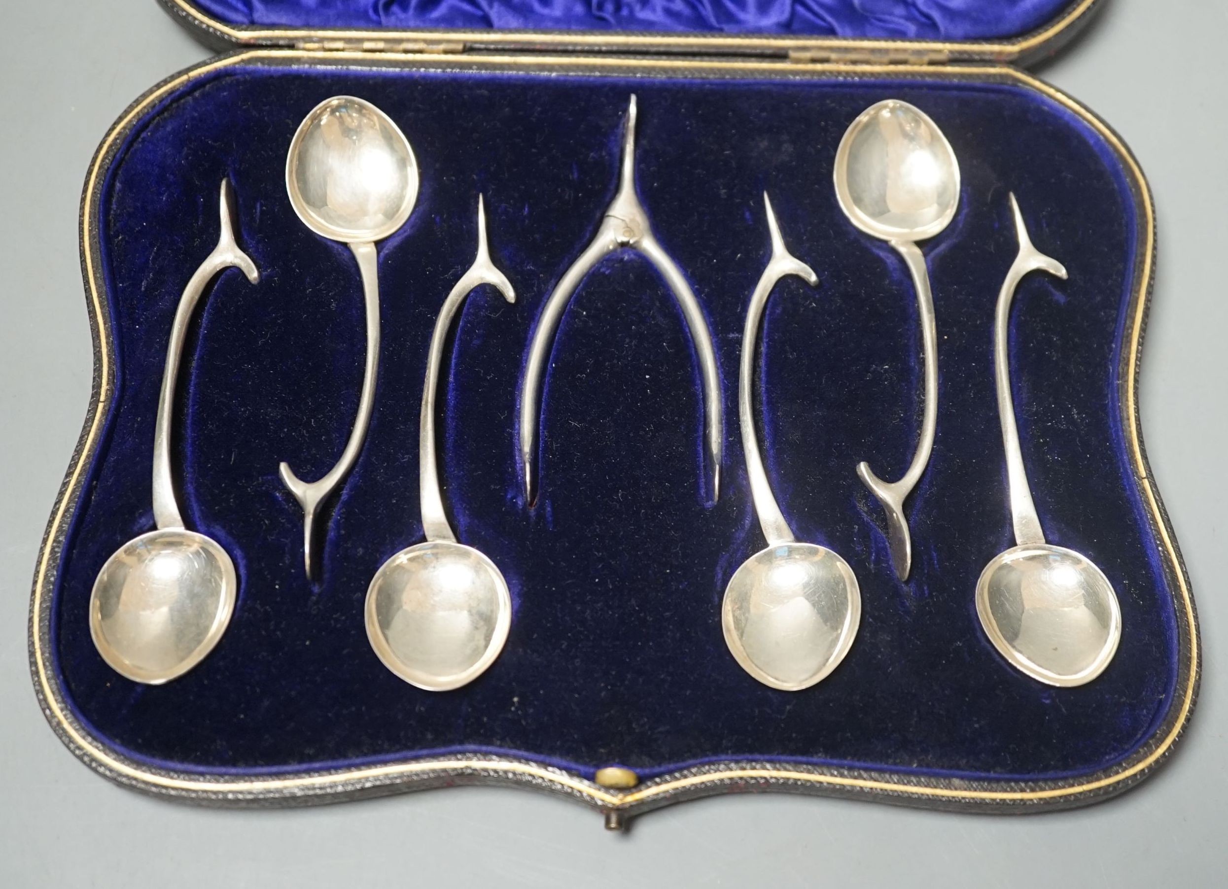 A novelty set of six Edwardian novelty silver wish bone handled teaspoons and matching sugar tongs, by William Hutton & Sons Ltd, Birmingham, 1905.